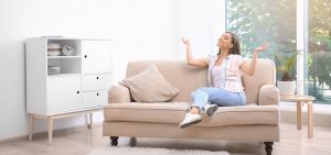 Woman sitting on couch enjoying her cool AC